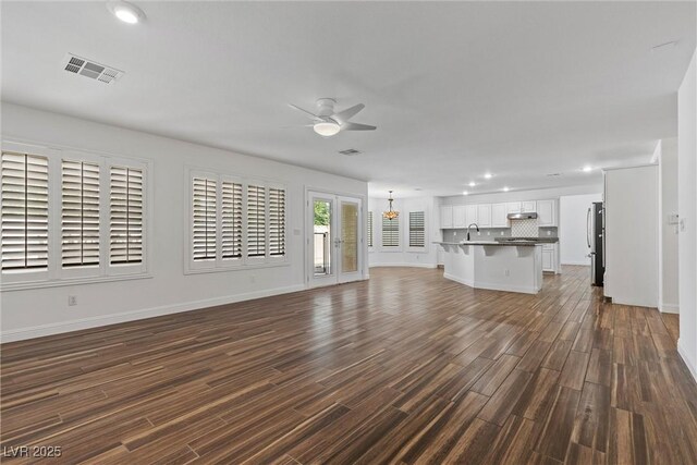 283 Grand Olympia Dr, Henderson, NV 89012 - unfurnished living room featuring ceiling fan, recessed lighting, baseboards, dark wood finished floors, and a chandelier
