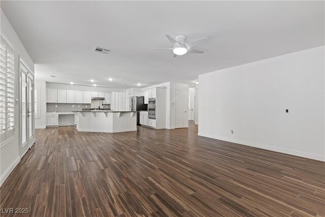 283 Grand Olympia Dr, Henderson, NV 89012 - unfurnished living room featuring a ceiling fan, dark wood-type flooring, baseboards, and recessed lighting