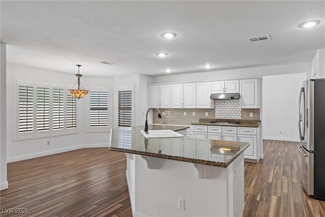 283 Grand Olympia Dr, Henderson, NV 89012 - kitchen featuring stainless steel appliances, a sink, under cabinet range hood, baseboards, and dark wood-style flooring
