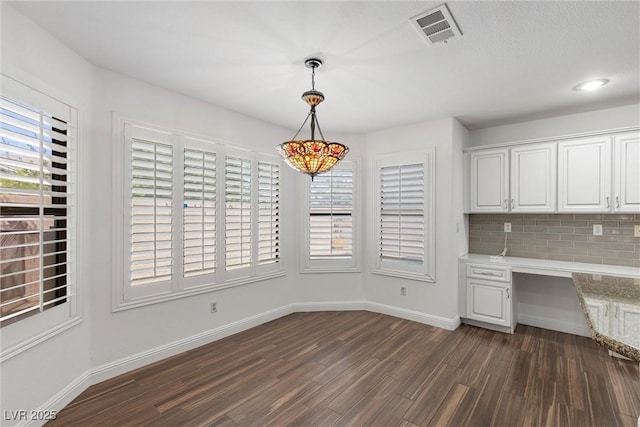 283 Grand Olympia Dr, Henderson, NV 89012 - unfurnished dining area with dark wood finished floors and baseboards