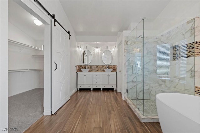 283 Grand Olympia Dr, Henderson, NV 89012 - full bathroom featuring a marble finish shower, a soaking tub, double vanity, wood finished floors, and a spacious closet