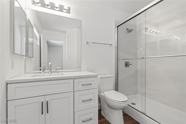 283 Grand Olympia Dr, Henderson, NV 89012 - full bathroom with wood finished floors, a shower stall, toilet, and vanity