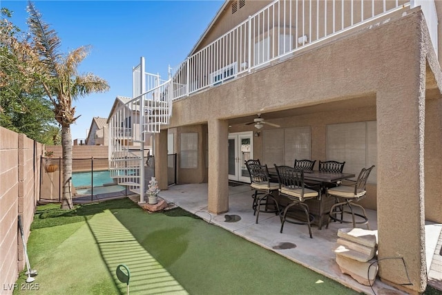 283 Grand Olympia Dr, Henderson, NV 89012 - rear view of house featuring a fenced backyard, stucco siding, an area to practice putting, a patio, and a ceiling fan