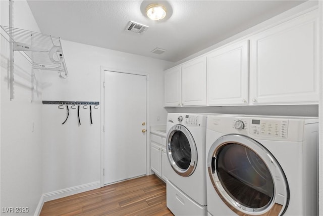 283 Grand Olympia Dr, Henderson, NV 89012 - laundry area featuring washer and dryer, light wood finished floors, cabinet space, and baseboards