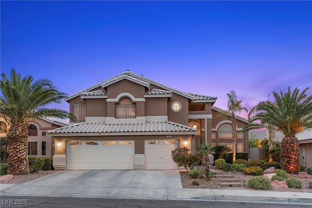 283 Grand Olympia Dr, Henderson, NV 89012 - mediterranean / spanish-style home featuring stucco siding, driveway, a tiled roof, and a garage