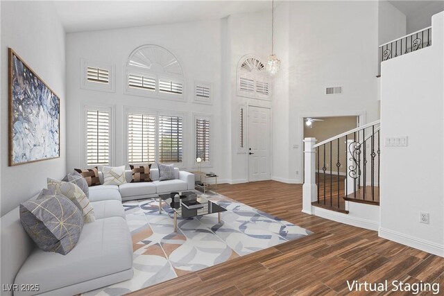 283 Grand Olympia Dr, Henderson, NV 89012 - living area with wood finished floors, stairway, a chandelier, high vaulted ceiling, and baseboards
