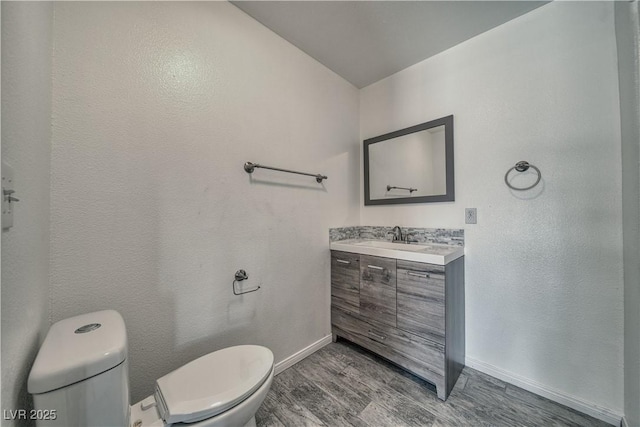 151 Hornet St, Pahrump, NV 89048 - half bath with toilet, baseboards, vanity, and wood finished floors