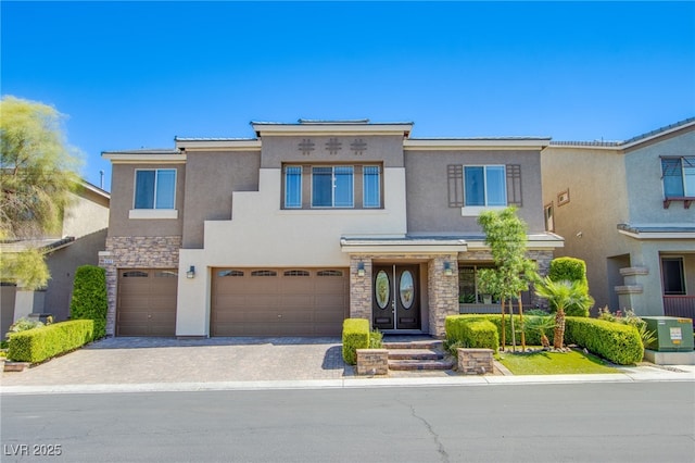 8303 Saddleback Ledge Ave, Las Vegas, NV 89147 - view of front of house featuring stucco siding, stone siding, a garage, and driveway