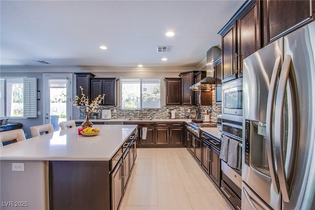 8303 Saddleback Ledge Ave, Las Vegas, NV 89147 - kitchen with appliances with stainless steel finishes, wall chimney exhaust hood, plenty of natural light, light countertops, and crown molding