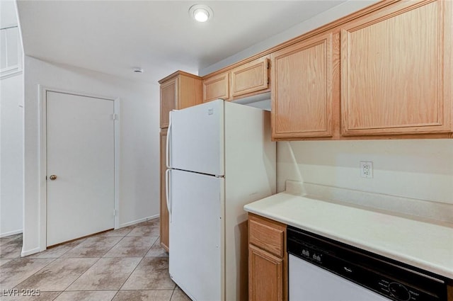 kitchen with light countertops, light tile patterned floors, light brown cabinets, and white appliances