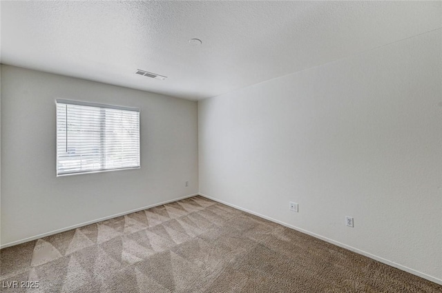 spare room featuring light colored carpet, baseboards, and visible vents