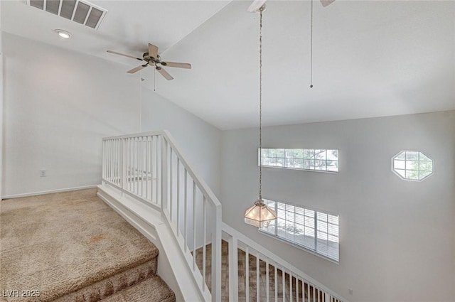 stairs with high vaulted ceiling, ceiling fan, baseboards, carpet flooring, and visible vents