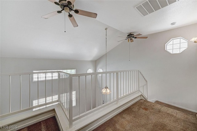 staircase featuring lofted ceiling, visible vents, baseboards, carpet flooring, and ceiling fan