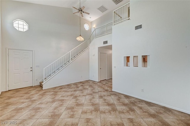 unfurnished living room featuring stairway, a high ceiling, visible vents, a ceiling fan, and light tile patterned floors