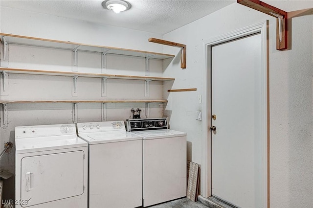 laundry area with washing machine and clothes dryer, a textured ceiling, and laundry area