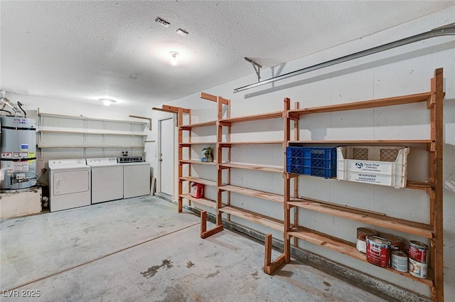 basement featuring a garage, washer and dryer, secured water heater, and a textured ceiling
