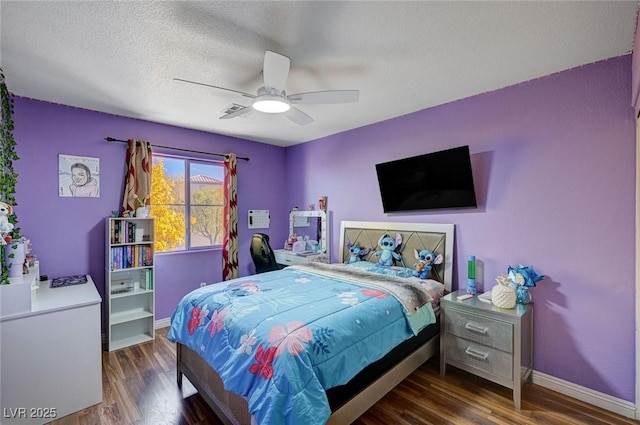 bedroom featuring wood finished floors, visible vents, a ceiling fan, baseboards, and a textured ceiling