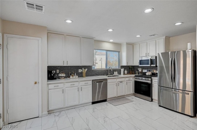 kitchen featuring a sink, visible vents, marble finish floor, light countertops, and appliances with stainless steel finishes