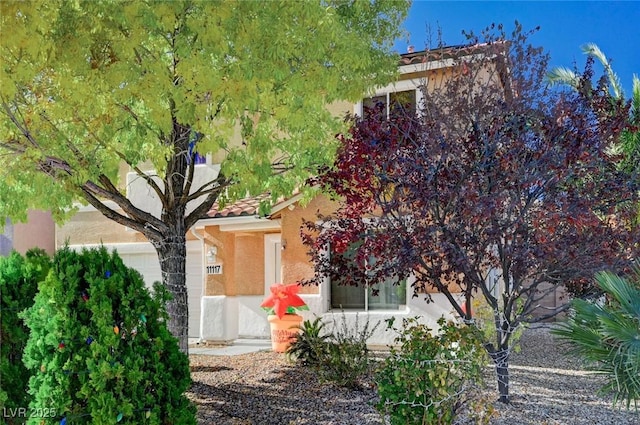 view of front of home with stucco siding, an attached garage, and a tile roof