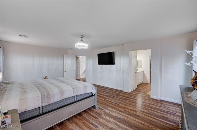 bedroom with baseboards, wood finished floors, and visible vents