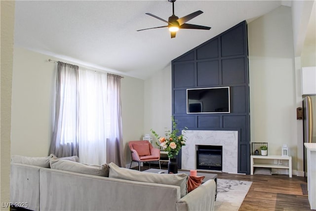 6198 Pinewood Ave, Las Vegas, NV 89103 - living area featuring wood finished floors, ceiling fan, a fireplace, and vaulted ceiling