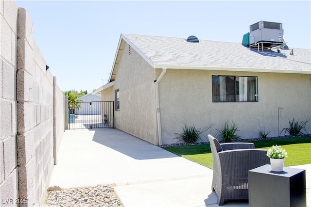 6198 Pinewood Ave, Las Vegas, NV 89103 - exterior space with a patio, central air condition unit, a shingled roof, stucco siding, and fence