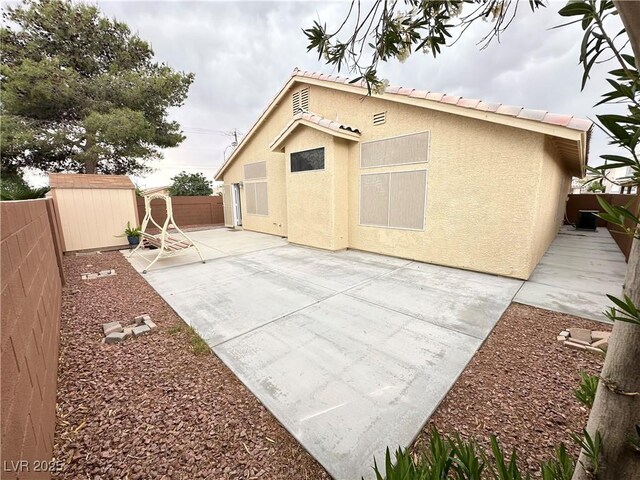 4484 Warbonnet Way, Las Vegas, NV 89147 - back of house featuring an outbuilding, a patio area, stucco siding, a fenced backyard, and a storage unit