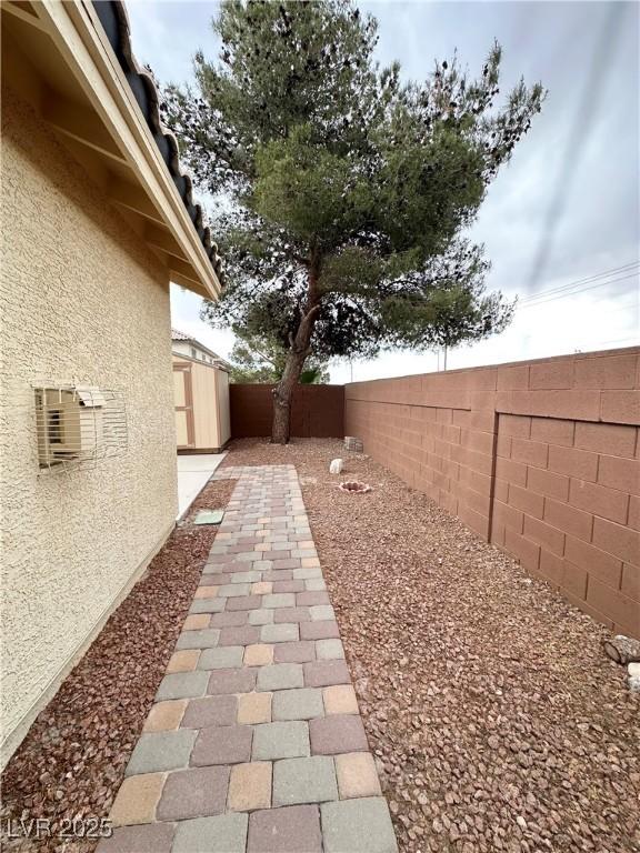 4484 Warbonnet Way, Las Vegas, NV 89147 - view of yard with an outdoor structure, a fenced backyard, and a storage unit