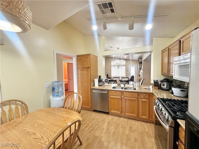 4484 Warbonnet Way, Las Vegas, NV 89147 - kitchen with light wood finished floors, a sink, rail lighting, visible vents, and appliances with stainless steel finishes