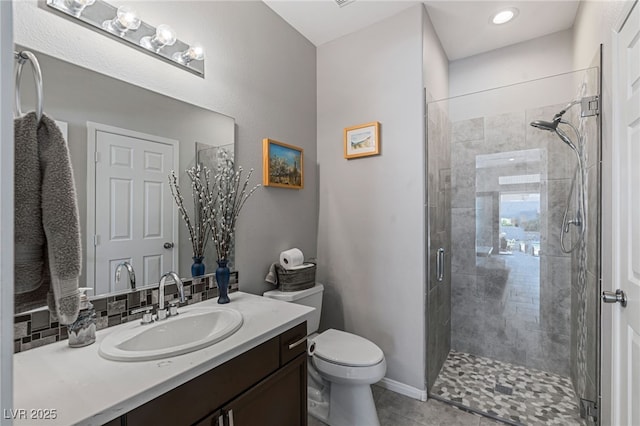 bathroom with toilet, tile patterned floors, a stall shower, vanity, and baseboards