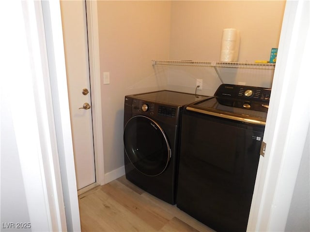 laundry room featuring washer and dryer, light wood-style floors, and laundry area