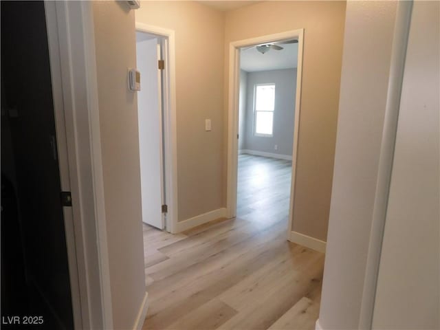 hall with baseboards and light wood finished floors