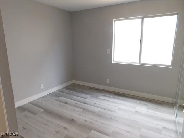 empty room with light wood-style flooring and baseboards