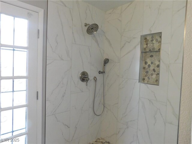 interior details featuring a marble finish shower
