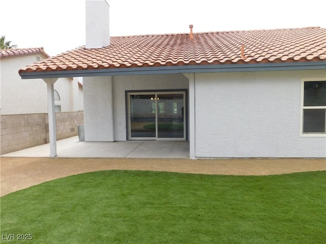 back of house featuring fence, a tile roof, a patio area, and stucco siding