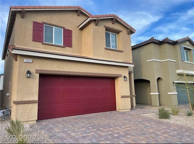 7892 W Shelbourne Ave, Las Vegas, NV 89113 - view of front facade featuring stucco siding, decorative driveway, and a garage