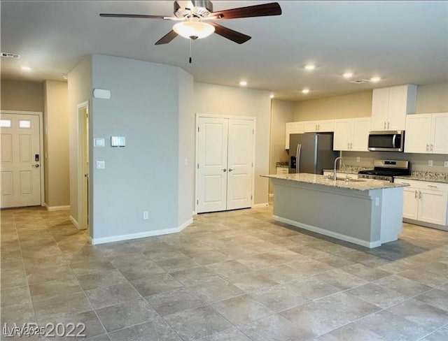 7892 W Shelbourne Ave, Las Vegas, NV 89113 - kitchen with a ceiling fan, a sink, a kitchen island with sink, appliances with stainless steel finishes, and white cabinetry