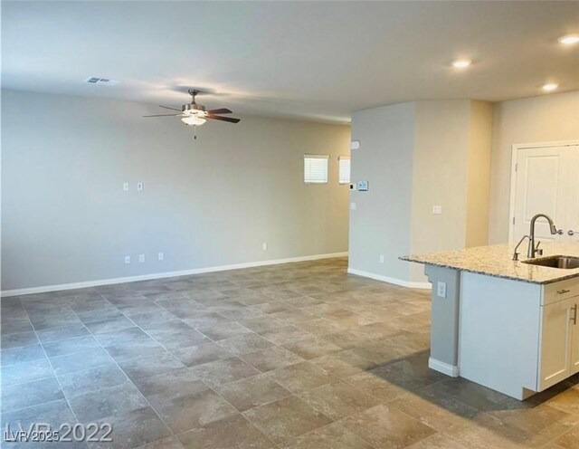 7892 W Shelbourne Ave, Las Vegas, NV 89113 - kitchen featuring a ceiling fan, a sink, light stone countertops, visible vents, and recessed lighting