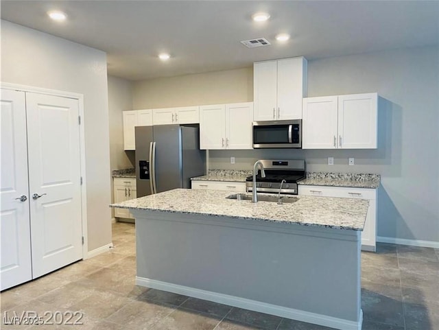 7892 W Shelbourne Ave, Las Vegas, NV 89113 - kitchen with a sink, stainless steel appliances, a center island with sink, white cabinets, and baseboards