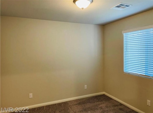7892 W Shelbourne Ave, Las Vegas, NV 89113 - empty room featuring baseboards, visible vents, dark carpet, and a wealth of natural light