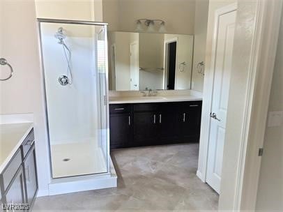 bathroom featuring a shower stall and vanity