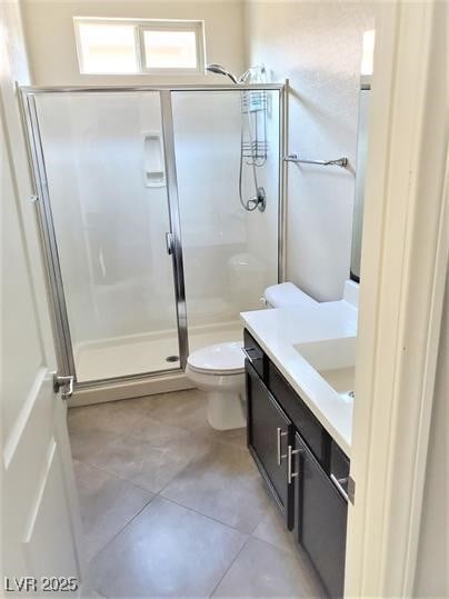 bathroom featuring a shower stall, toilet, vanity, and tile patterned floors