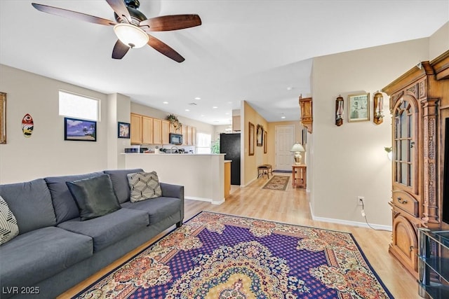 living room featuring light wood-type flooring, a ceiling fan, baseboards, and recessed lighting