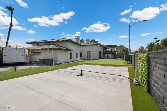 rear view of property with a chimney, fence, cooling unit, a patio, and stucco siding
