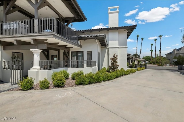 2715 Twin Palms Cir, Las Vegas, NV 89117 - view of side of property with a balcony, a chimney, and stucco siding