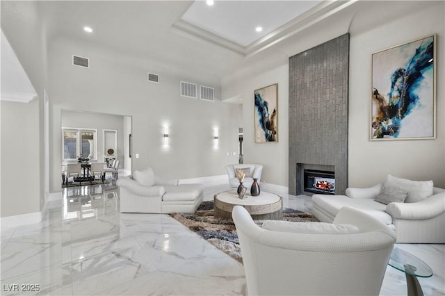 2715 Twin Palms Cir, Las Vegas, NV 89117 - living room with marble tiled floors, recessed lighting, a fireplace, a high ceiling, and a raised ceiling