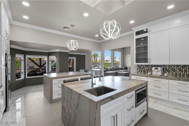 2715 Twin Palms Cir, Las Vegas, NV 89117 - kitchen featuring open floor plan, stainless steel microwave, a center island with sink, a chandelier, and recessed lighting