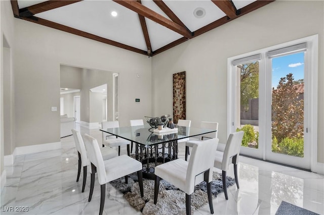 dining space with high vaulted ceiling, marble finish floor, baseboards, and beam ceiling