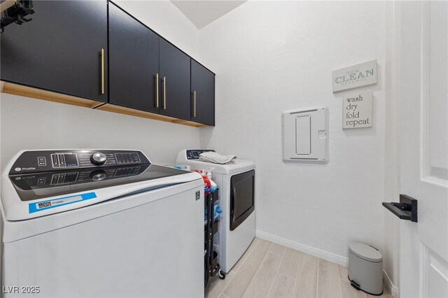 washroom featuring baseboards, wood finish floors, cabinet space, and washer and dryer