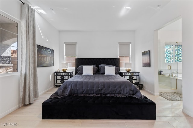 bedroom featuring connected bathroom and baseboards